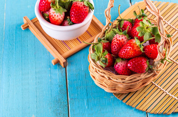 Fresh strawberries in a bowl on wooden table