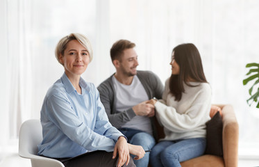Professional Marital Therapist Smiling While Clients Reconciling Sitting In Office
