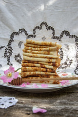 Delicious homemade thin pancakes on a beautiful plate. Russian kitchen