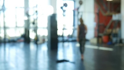 Bokeh shot. Young sports woman entering a fitness club and preparing for the training. 