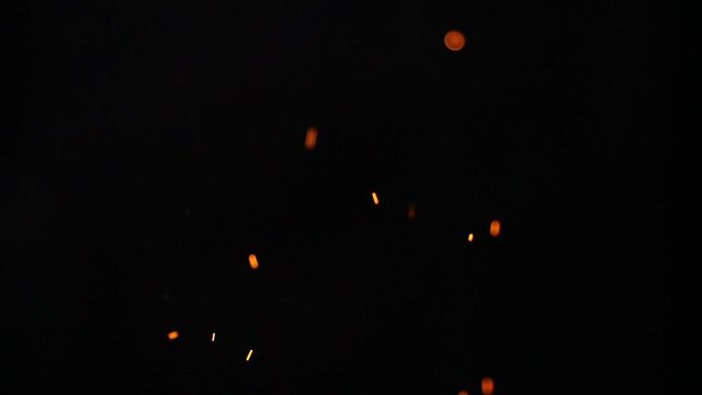 Sparkling  and flying up sparkles for using in composition,  on black backdrop isolated. Screen mode for blending or transitions.  Bright flames of fire over black   background, slow motion 200 fps