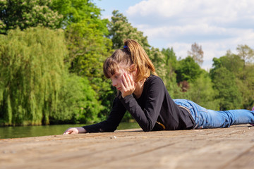 Fototapeta premium Girl relaxing by the river on hot sunny day