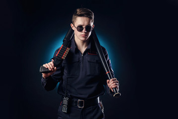handsome guy in a police officer's uniform with a gun and a baseball bat