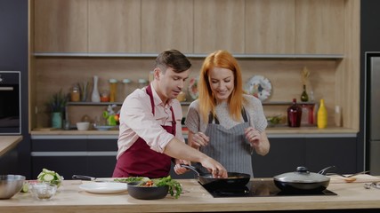 Cooking show hosts chefs, male and female, cooking meat. Morning TV cooking programme