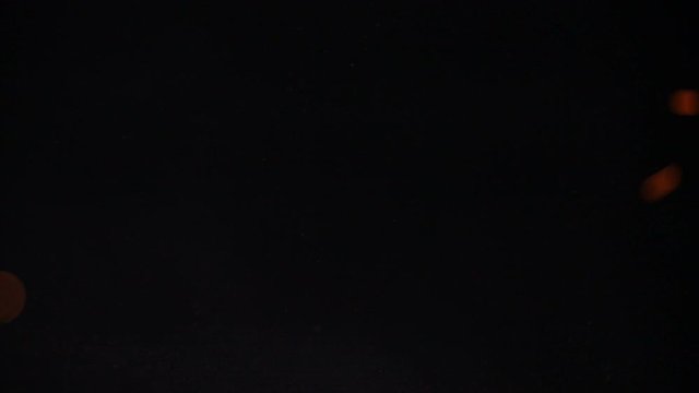Sparkling  and flying up sparkles for using in composition,  on black backdrop isolated. Screen mode for blending or transitions.  Bright flames of fire over black  background, slow motion 200 fps