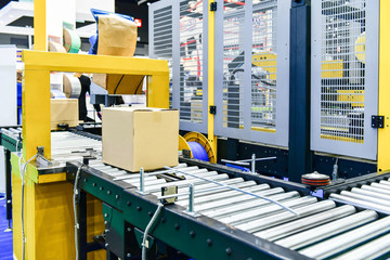 cardboard boxes on conveyor belt in distribution warehouse.parcels transportation system concept.