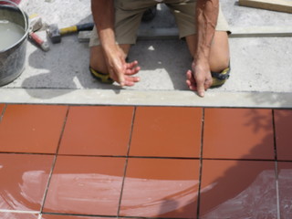 worker tiler metre laying tiles intent in his work