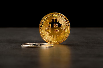 Pair of bitcoin coins (gold and silver) on black background