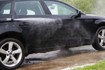 Cleaning car using high pressure water. outdoor.