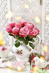 pink roses in porcelain jug in vintage style interior