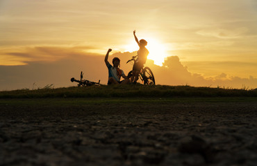 Young Couple in love fun and happy riding mountain bike after covid-19 coronavirus outbreak. End of the coronavirus outbreak. Silhouette cycling man and woman riding mountain bike at sunset time.