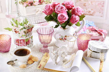 bouquet of pink roses in jag on the table with coffee and notebo