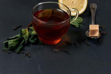 tea with mint and lemon on a dark background