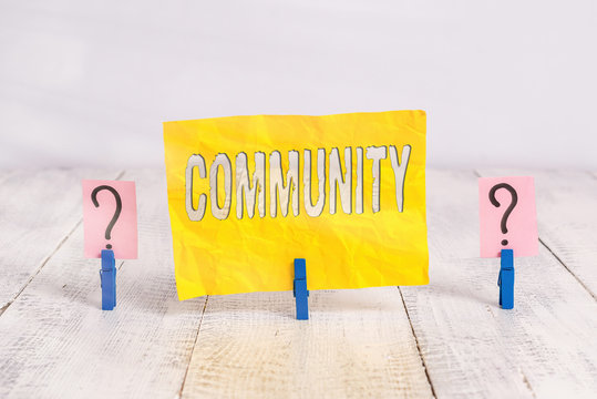 Writing note showing Community. Business concept for specific population with a common characteristics living together Crumbling sheet with paper clips placed on the wooden table