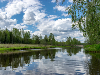Fototapeta na wymiar landscape with a beautiful river in spring, cloud reflections in the water