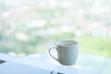 brake time with a ceramic mug of coffee and city view though window