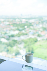 brake time with a ceramic mug of coffee and city view though window