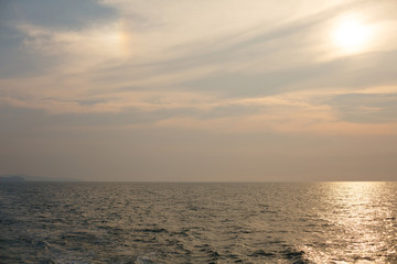 Natural background. The sun goes down to the horizon above the sea or ocean. Sunset over the water.