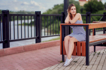 Bench on the bridge with a sitting girl in a dress.