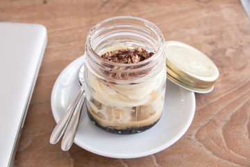 Delicious Banoffee in Mason jar on wood background