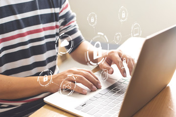 Close-up image of male hands using computer laptop with icon graphic cyber security network of...