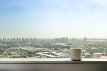 brake time with a ceramic mug of coffee and city view though window