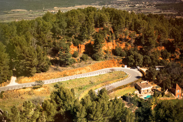 Picturesque panoramic road between ocher hills near medieval village Roussillon, one of the most...