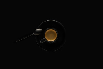 black cup of espresso with black spoon on black background