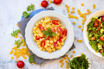 Cooked pasta tubes dish with red sauce, tomatoes and rucola herb spice. Vegan food lunch