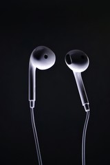 White earphone with black background. Earphone and audio jack with black background.