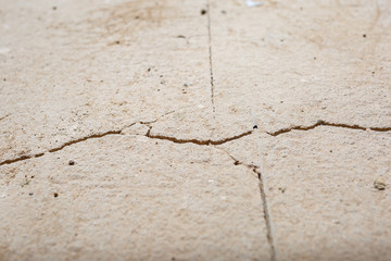 Cracks in the concrete cement screed on the floor after repair. The concrete surface texture is covered with web cracks. Gray stone background