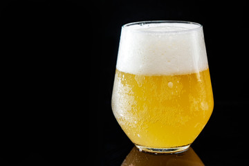 close-up of a beautiful glass with beer on a black background