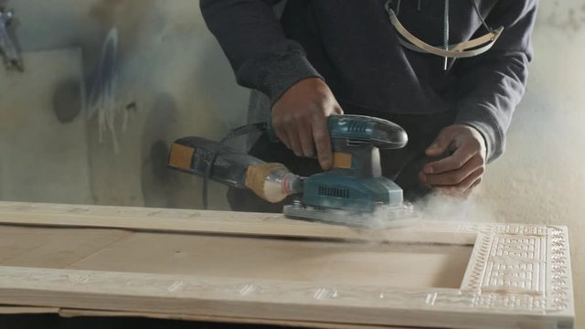 Wood sanding machines , Carpenter working with electrical sander on a surface