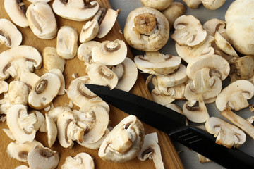 Knife cuts mushrooms on a wooden cutting Board