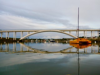 Bateau dans un port calme avec un pont en arriere plan