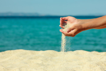 Fototapeta na wymiar female hand pours sand