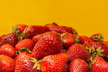 Fresh tasty strawberries on yellow background. Summer time concept
