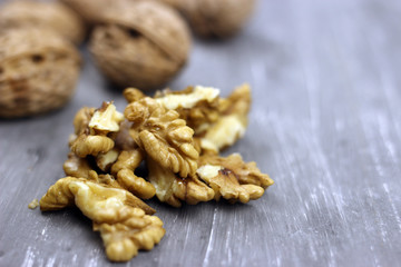 Walnut kernels and whole nuts on an old gray table. Seletive focus