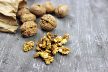 Walnut kernels and whole nuts on an old gray table. Seletive focus