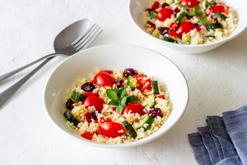 Couscous salad with tomatoes, peppers, courgettes and cranberries. Vegetarian food. Diet. Healthy eating.
