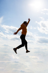 Fototapeta premium guy tourist freelancer on a background of blue sky with white clouds, bright sunny day, nature and human freedom