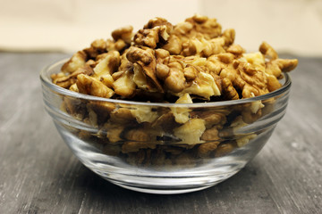 walnut kernels in a bowl on a gray background