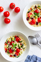 Couscous salad with tomatoes, peppers, courgettes and cranberries. Vegetarian food. Diet. Healthy eating.