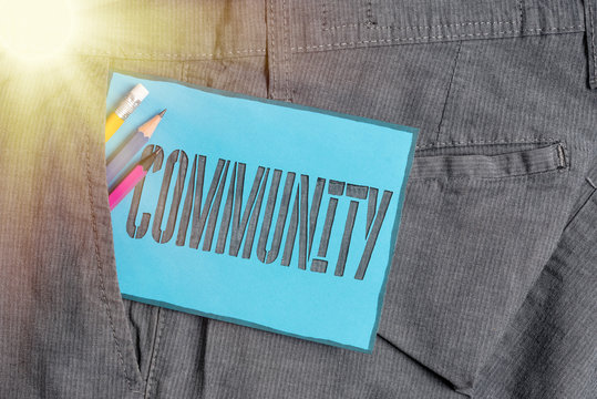 Conceptual hand writing showing Community. Concept meaning specific population with a common characteristics living together Writing equipment and blue note paper in pocket of trousers