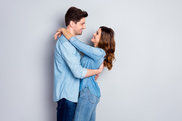 Profile photo lady guy couple in love cuddle hugging together holding hands romantic feelings slow dance look eyes wear casual denim shirts outfit isolated grey color background