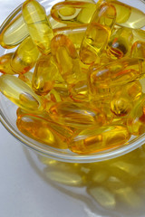 Fish oil capsules on a glass plate. A lot of vitamin omega 3. Close-up.