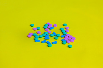 Handful unpacked pills on the yellow background