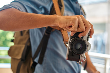 traveler with blue shirt, backpack and plate and black camera