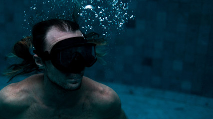 sporty man swimming in mask in pool
