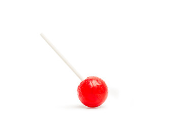 Piruleta roja de fresa con palo sobre fondo blanco liso y aislado. Vista de frente. Copy space